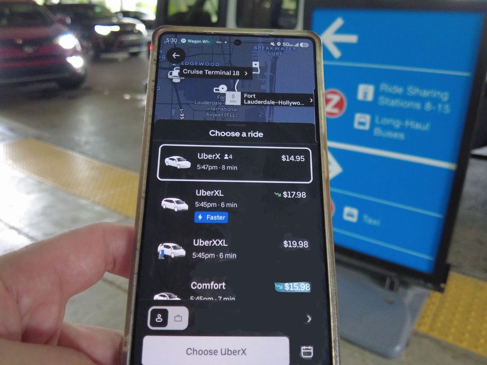 Requesting an Uber on a phone at the Fort Lauderdale airport ride share pickup area