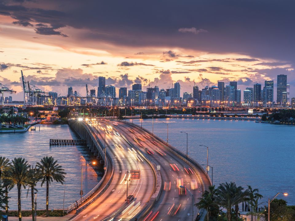 Miami skyline at dusk with traffic light trails on the MacArthur Causeway