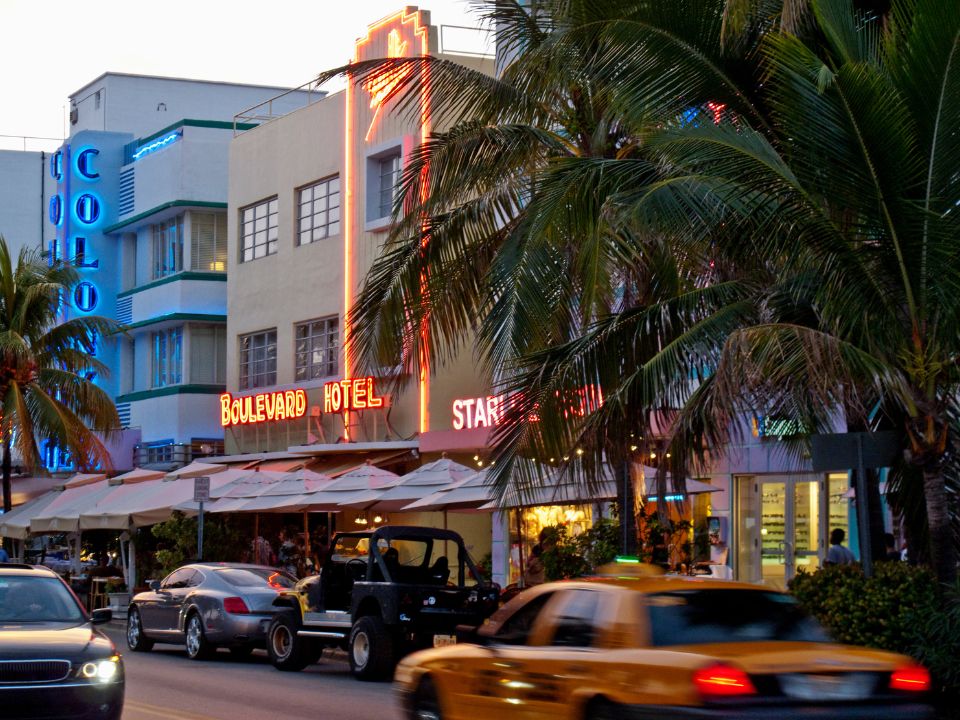Yellow taxi passing Art Deco hotels on Ocean Drive in South Beach, Miami